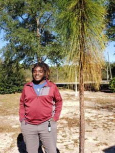 Ronald smiling next to a longleaf pine.